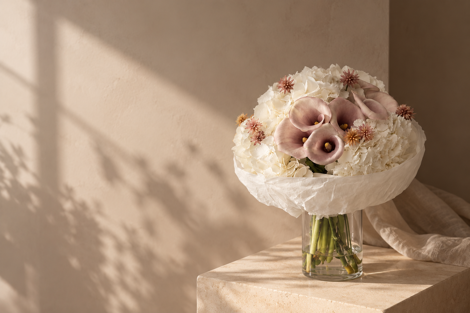 Calla lilies and white hydrangea bouquet in a glass vase